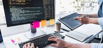 Code on tablet and monitor with highlighters and post its