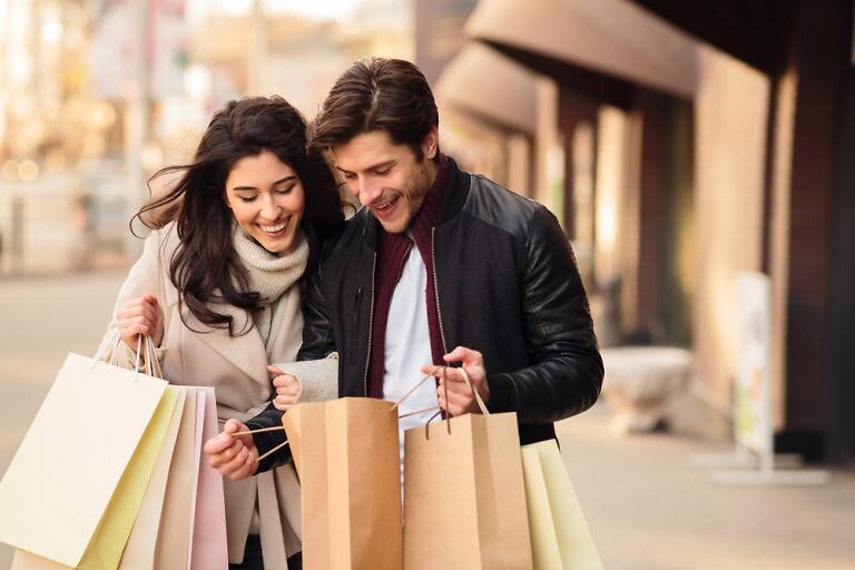 man and woman shopping on Black Friday with shopping bags