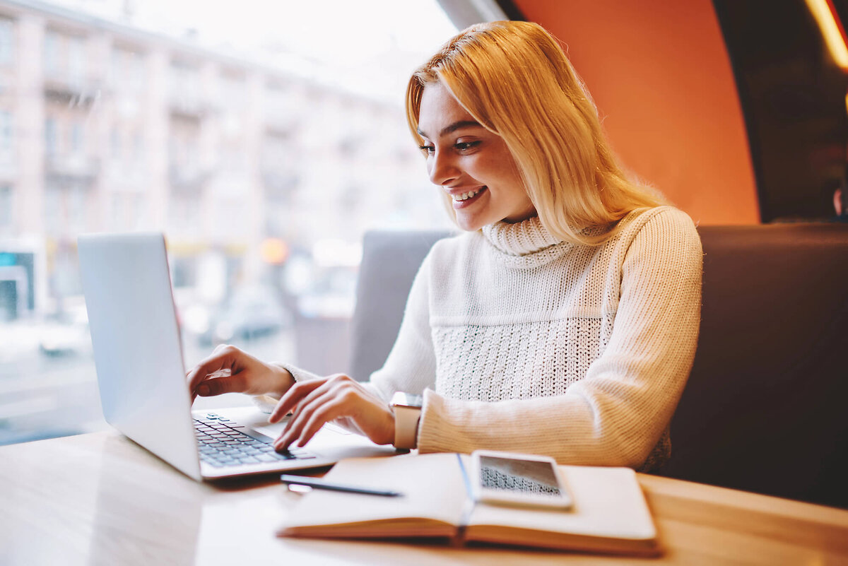 Woman smiling and typing on laptop