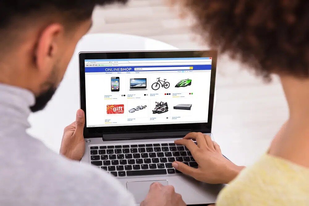 2 people on laptop with ecommerce page