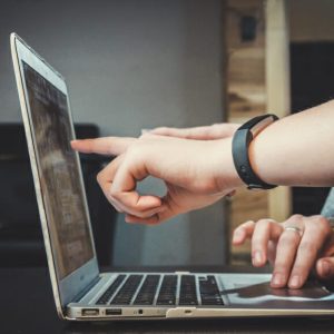 people pointing at code on screen